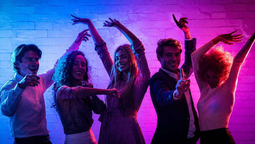Solteros bailando en una fiesta retro con luces de colores